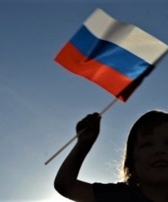 Девятилетняя девочка из ДНР встречает самолёты ВКС России с флагом в руках
