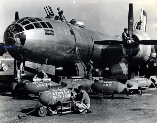 Техники загружают боеприпасы на бомбардировщик B-29 перед вылетом на бомбардировку Токио