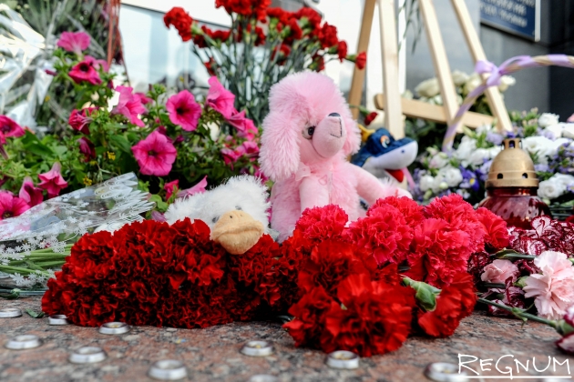 Цветы и мягкие игрушки у департамента труда и социальной защиты населения в память о детях, погибших в Карелии