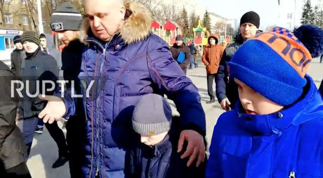 Вице-губернатор Кемеровской области Сергей Цивилев обнимает детей, перед которыми он встал на колени