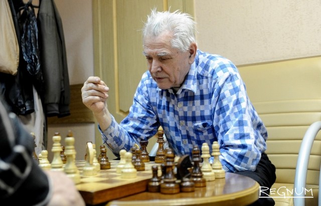 Пожилой человек за игрой в шахматы