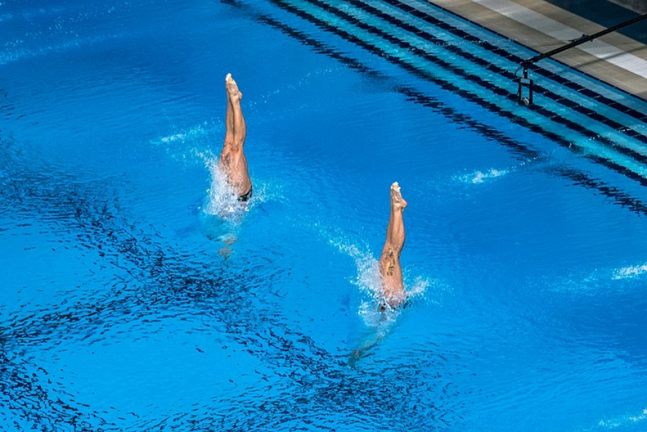 Спортсмен прыгает с вышки в воду