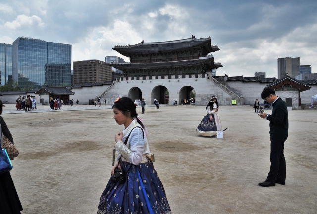 Один из культурных трендов Южной Кореи – прогулка в традиционном корейском костюме (ханбоке). Главные ворота дворца Кёнбоккун. Сеул, Южная Корея