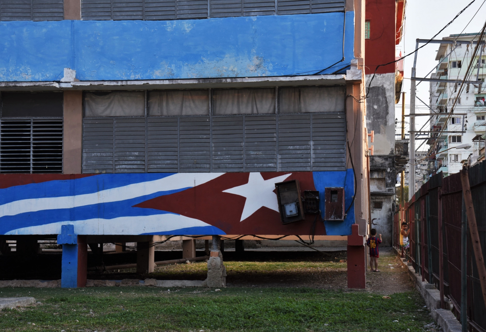Флаг Кубы на стене одной из общеобразовательных школ Гаваны.  Синие полосы — три исторических промежутка, белые полосы — символ независимости, красный треугольник означает свободу, равенство и братство