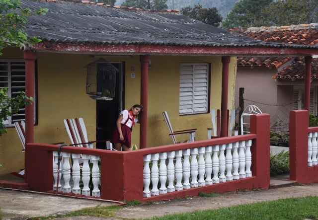 Образование на Острове Свободы бесплатное, полностью финансируемое государством. Девочка в школьной форме на крыльце своего дома. Виньялес, Куба