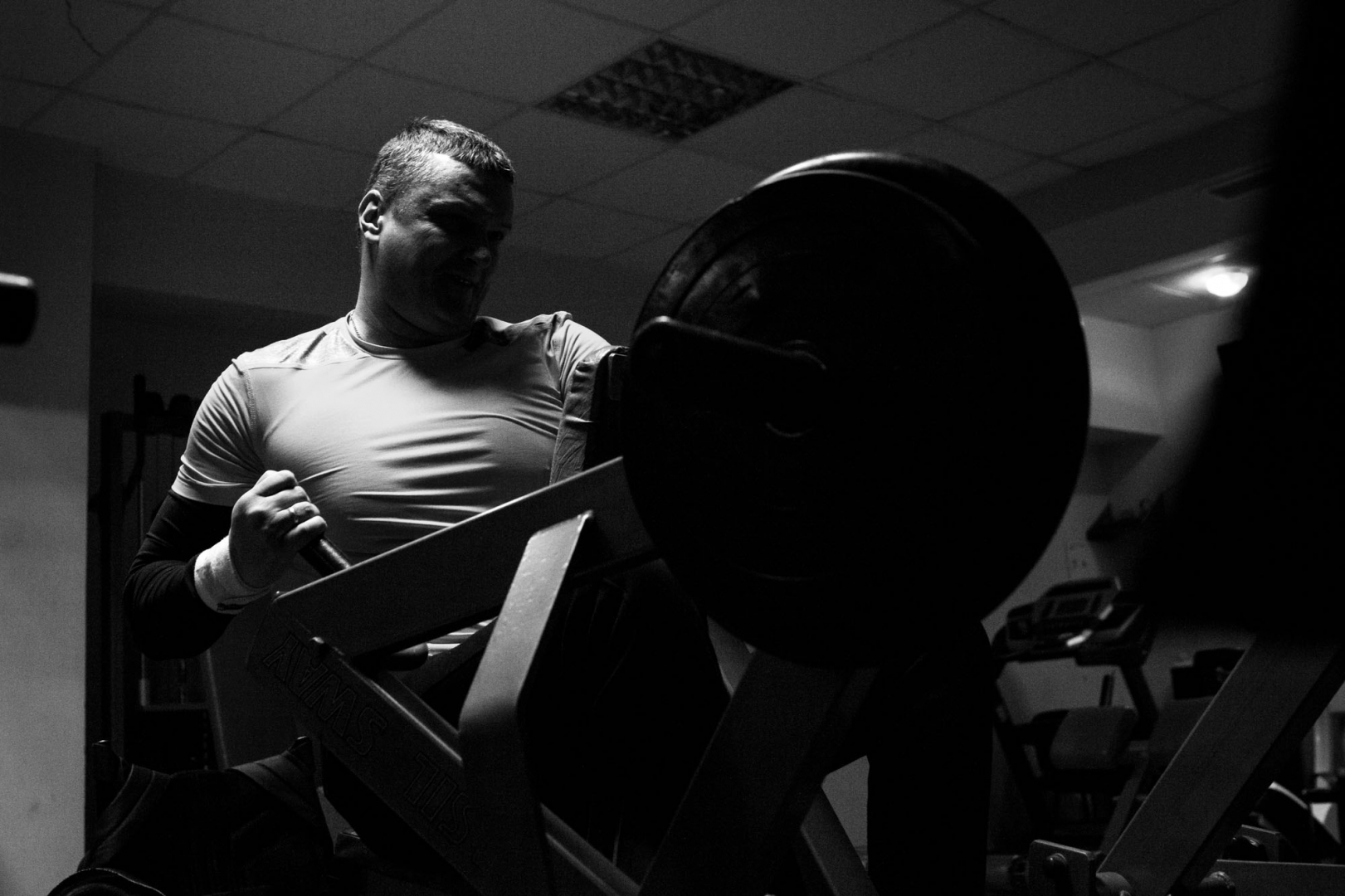 Андрей делает упражнение на развитие мышц спины во время тренировки в тренажерном зале. На соревнованиях спортсменам приходится в течение целого часа держать винтовку весом около 8 кг 