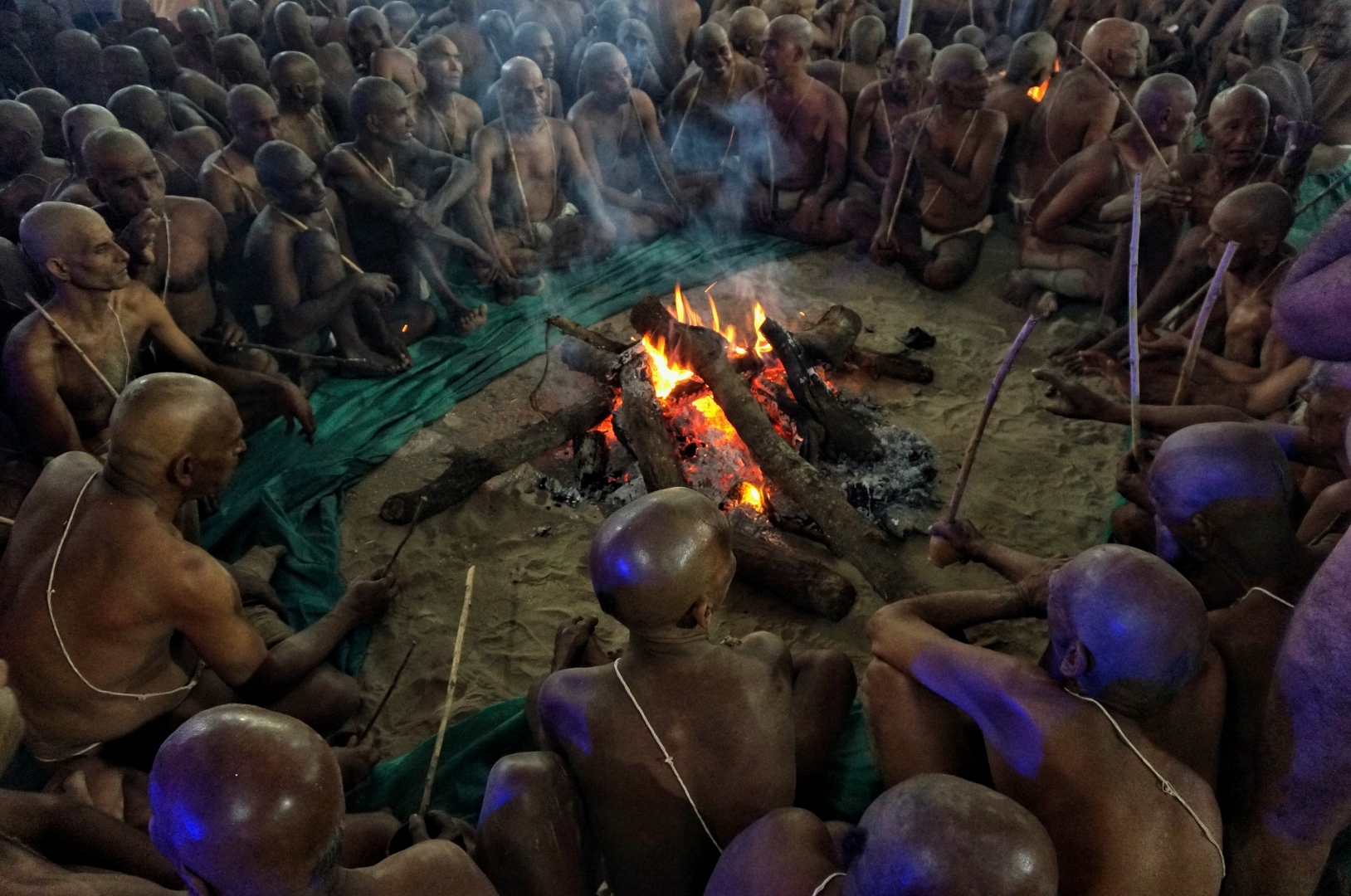 После дневных церемоний на берегу Ганга будущие садху всю ночь поют мантру у большого ритуального огня