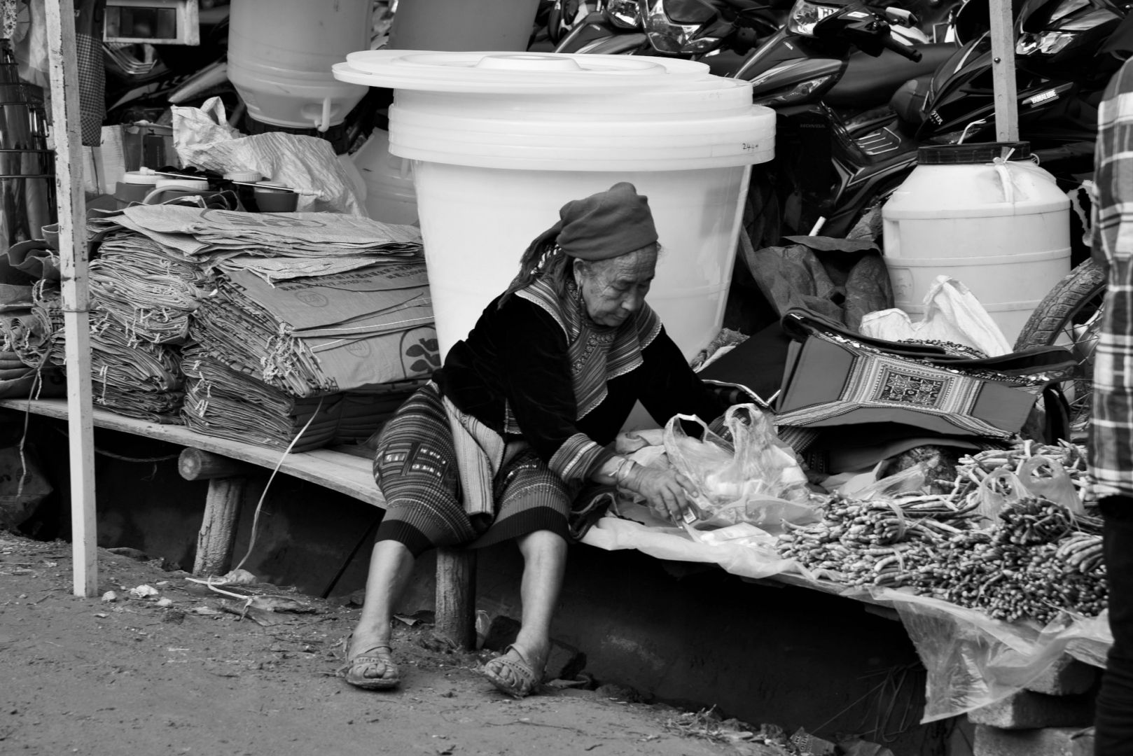 Пожилая женщина хмонгов раскладывает свой товар на субботнем рынке в Кан Кау. Северный Вьетнам