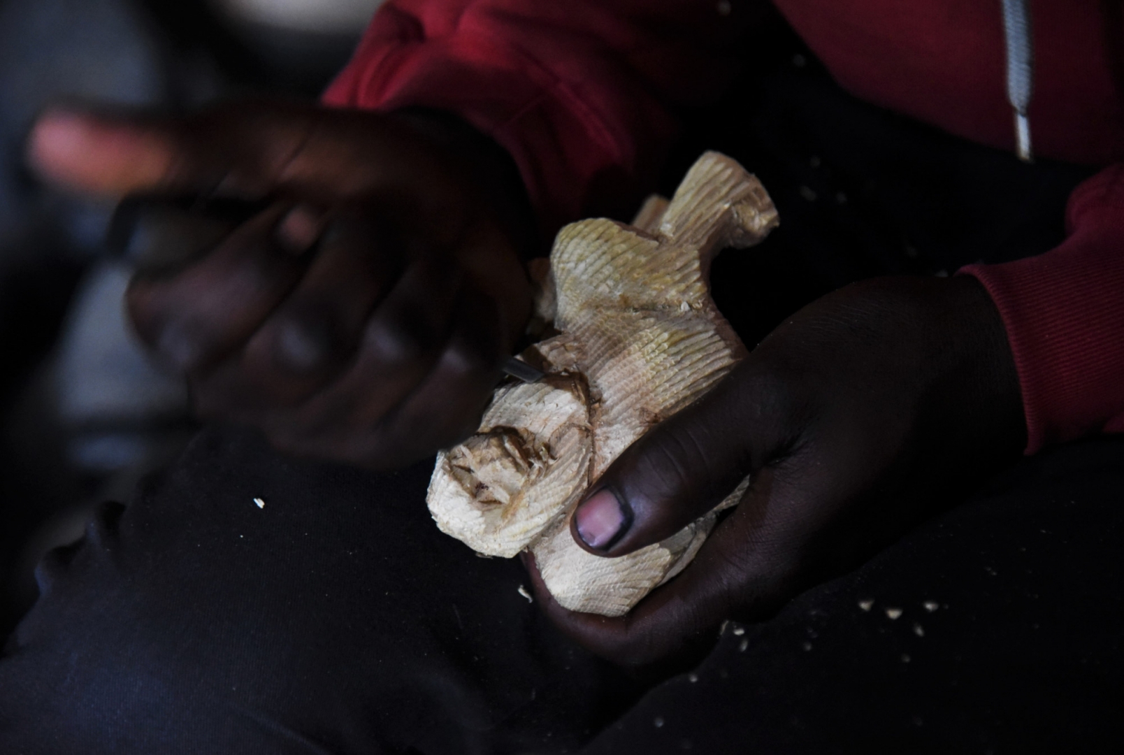 Местный житель вырезает фигурку горной гориллы. Район вулканов Вирунга, Руанда, Африка