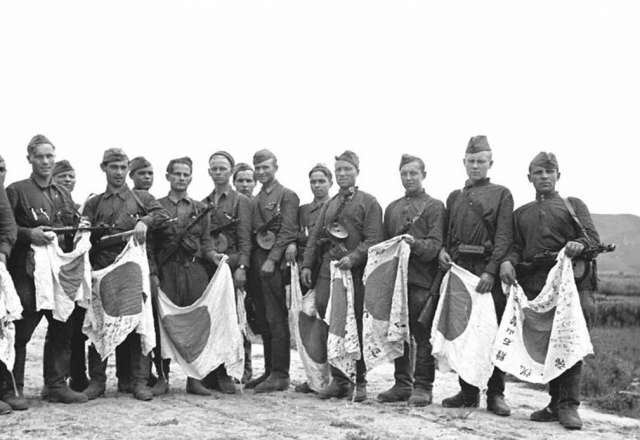 Советские солдаты с трофейными японскими флагами. 1945