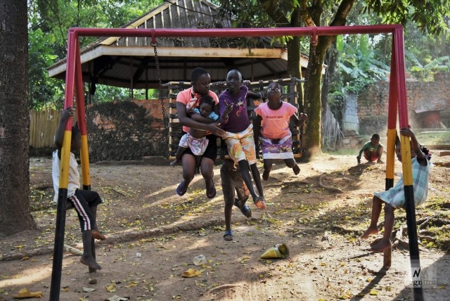 Дети качаются на качелях во дворе детского дома. Window of Life, Масинди, Уганда