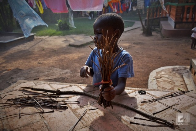 Эриа (7 лет) собирает новую метлу из прутьев во дворе детского приюта. Window of Life, Масинди, Уганда