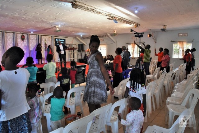 Каждую неделю дети с опекунами-«тётями» ходят в баптистскую церковь на воскресную мессу. Хоуп с детьми во время молитвы. Masindi Miracle Centre Church, Уганда