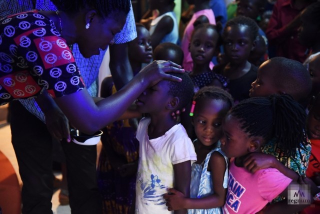 Благословение детей перед новым школьным семестром. Джефри (6 лет) получает благословение, Пэнина (4 года) ожидает своей очереди, общаясь с местной девочкой. Masindi Miracle Centre Church, Уганда