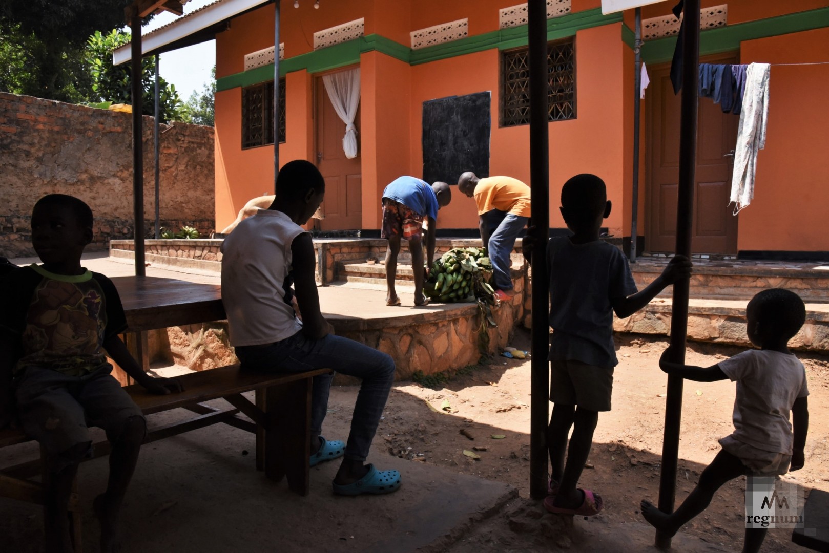 Старшие мальчики переносят платаны (овощные бананы) в подсобное помещение для хранения. Window of Life, Масинди, Уганда