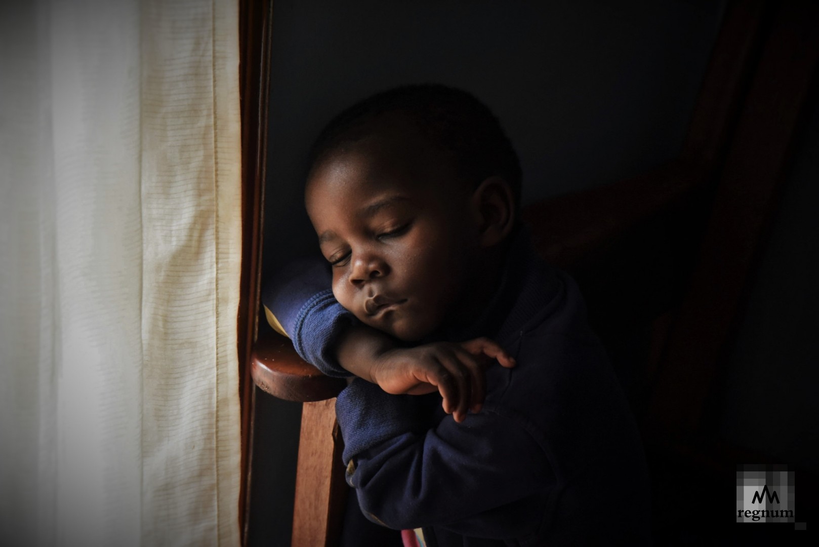 Сандэй (3 года) спит на скамейке у окна в одной из комнат детского дома Window of Life. Масинди, Уганда