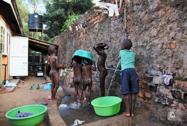 Летний душ во дворе Window of Life. Дети моются самостоятельно. Малышам помогают воспитатели «тёти» и старшие дети. Масинди, Уганда