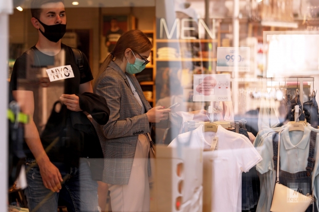 Посетители в масках в магазине одежды