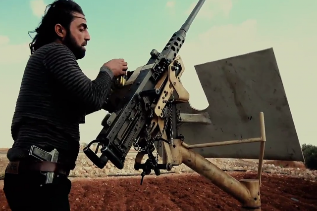 Боевик Свободной сирийской армии (ССА) заряжает крупнокалиберный пулемет M2 Browning. Алеппо, Сирия