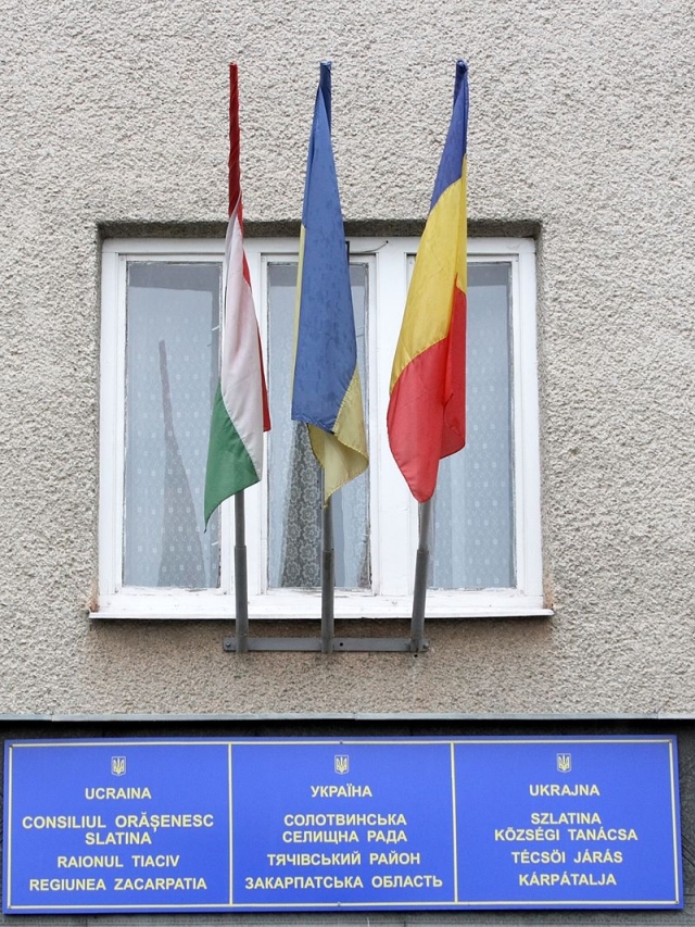 Флаги Венгрии и Румынии и надписи на венгерском и румынском языках на здании Солотвинского совета. Западная Украина 