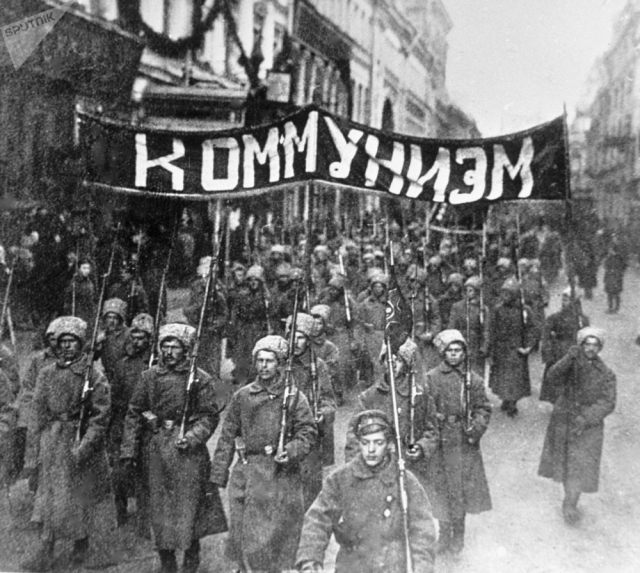 Колонна революционно настроенных солдат с лозунгом «Коммунизм» идет по Никольской улице в Москве. 1917 год