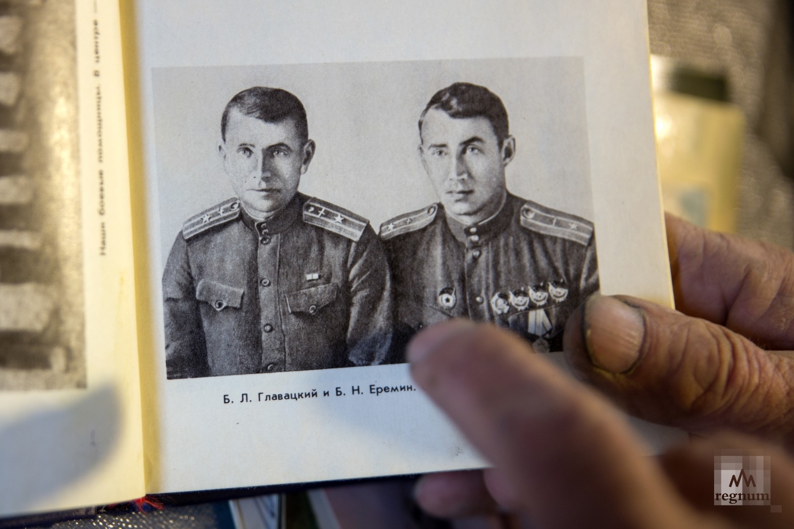 Валентин Борисович Главацкий в своей мастерской, показывает книгу, в которой сохранились сведения об отце