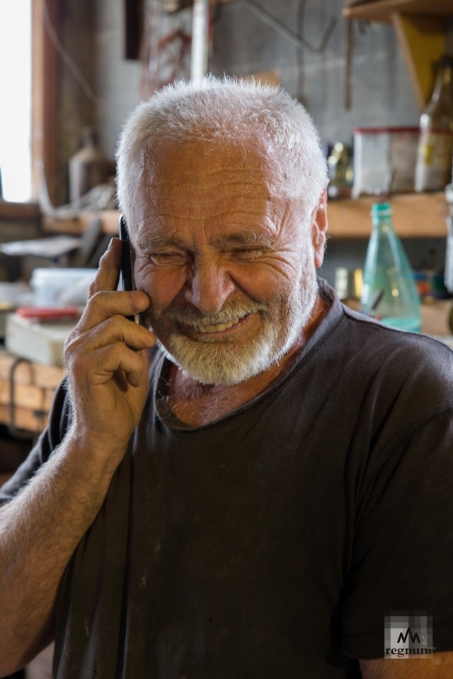 Валентин Борисович Главацкий в своей мастерской разговаривает с другом по телефону