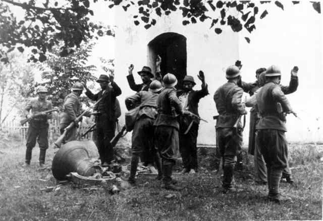Хорватские усташи обыскивают крестьян у церкви в югославской деревне Босанска-Дубица. 1941