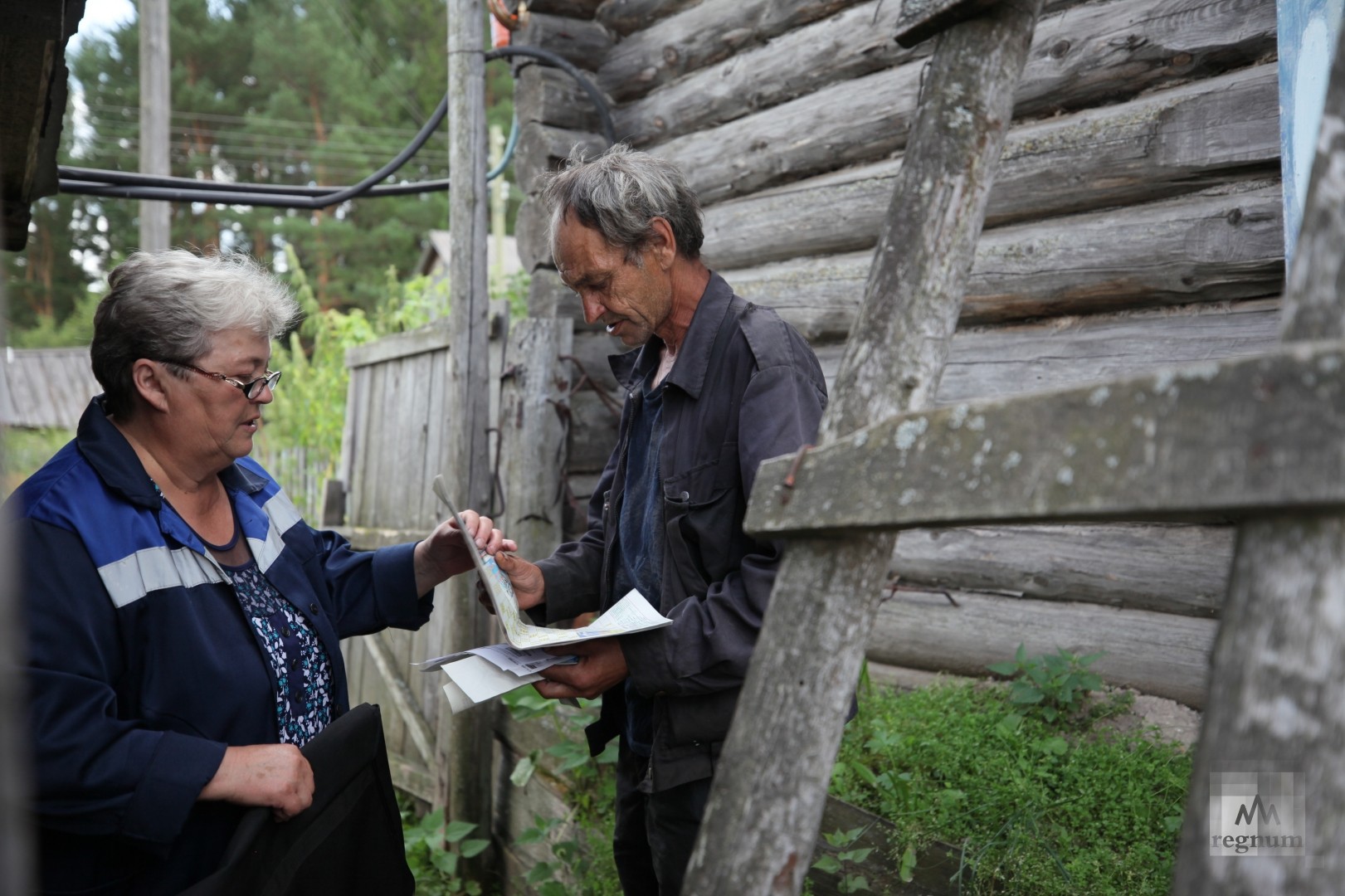 Галина Александровна передаёт районную газету Владимиру  Негодаеву, одному из последних жителей деревни Пихтовое