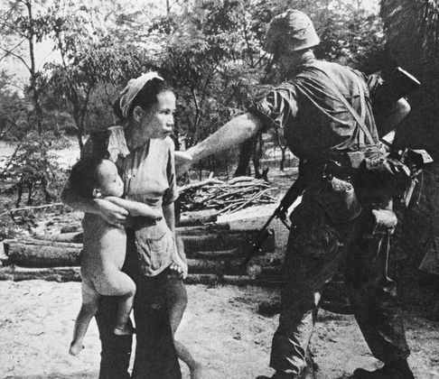 Вьетнамская женщина защищает своих детей от американских морских пехотинцев