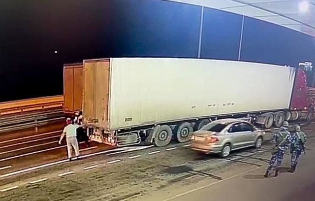 Сотрудник ДПС досматривает грузовой автомобиль на Крымском мосту