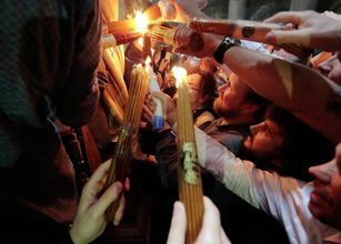 Верующие со свечами, зажженными от Благодатного огня в храме Гроба Господня
